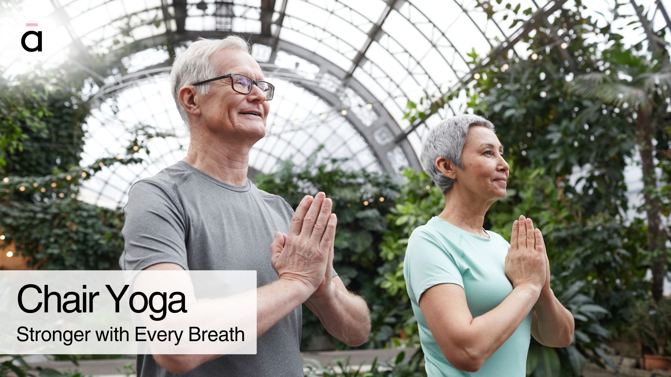 Two seniors smiling during a seated yoga practice—demonstrating that chair yoga is effective for strength and mobility.