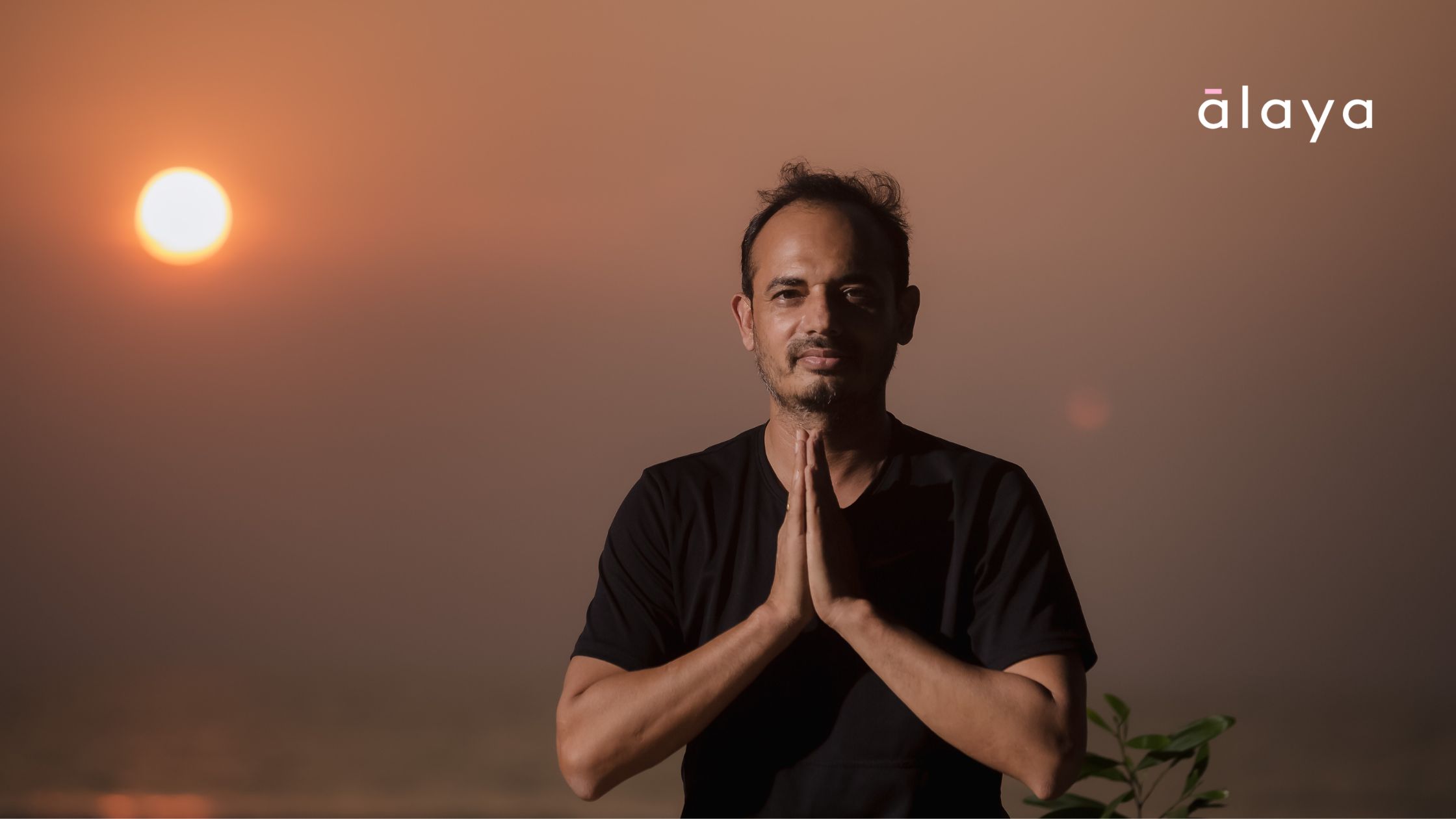 Yogacharya Lalit in prayer pose at sunset, inviting new students to explore this practice