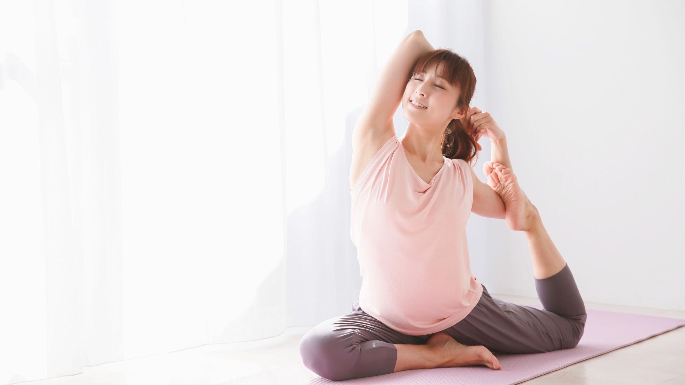 Person stretching on a yoga mat in natural light, showing the benefits of a short morning yoga practice.